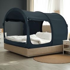 a bed that is in the middle of a room with a canopy on top of it