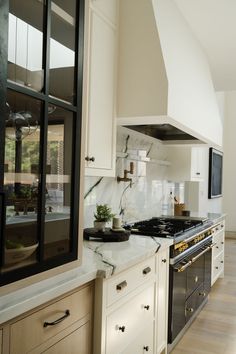 a kitchen with white cabinets and marble counter tops