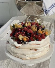 a cake with fruit on top sitting on a table