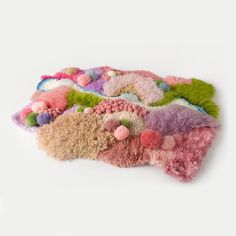 a pile of multicolored rugs sitting on top of a white floor next to each other