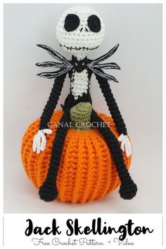 a crocheted jack skellingington doll sitting on top of an orange pumpkin