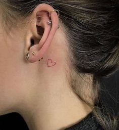 a woman with a heart tattoo on her ear