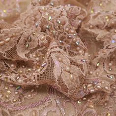 Elevate your creations with our exquisite Light Brown Floral Heavily Beaded Embroidered Lace. Meticulously crafted with intricate floral patterns, this lace features delicate beadwork that shimmers with elegance. The light brown hue provides a versatile backdrop, perfect for complementing a variety of colors and styles. Ideal for adding a touch of sophistication to evening gowns, bridal wear, and upscale fashion pieces, this lace ensures every design stands out with grace and grandeur. Our heavi Elegant Lace Fabric With Pearl Embroidery, Elegant Beige Embellished Embroidered Fabric, Elegant Embellished Lace For Festive Occasions, Elegant Beige Lace With Floral Embroidery, Elegant Lace With Intricate Embroidery For Festive Occasions, Beige Lace Fabric With Pearl Embroidery, Party Lace Fabric With Pearl Embroidery, Beige Pearl Embroidered Lace Fabric, Cream Lace Embroidered Fabric For Party