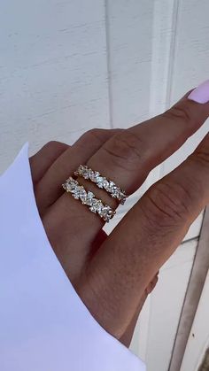 a woman's hand with two rings on it and one ring in the middle