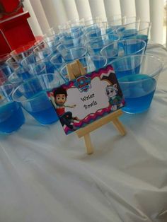 a table with blue cups and a sign on it