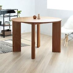 a wooden table sitting on top of a hard wood floor next to a white chair