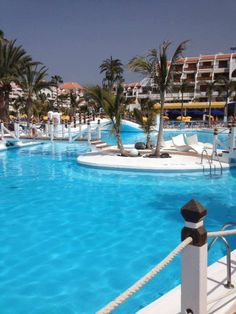 an outdoor swimming pool with water slides and palm trees in the backgrouds