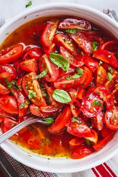 a white bowl filled with sliced tomatoes and basil