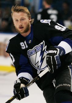 a man in black jersey skating on ice