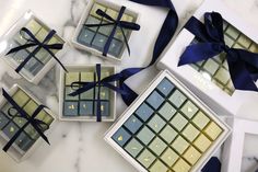 four different types of chocolates wrapped in blue and gold ribbon on a marble surface