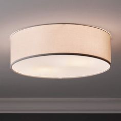 a ceiling light with a beige shade on it