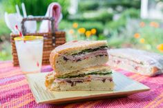 two sandwiches stacked on top of each other on a plate next to a glass of milk