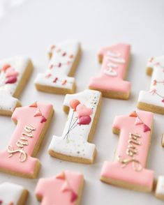 decorated cookies with pink and white frosting are arranged on a table