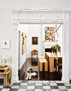 a dog laying on the floor in a living room next to a table and chairs