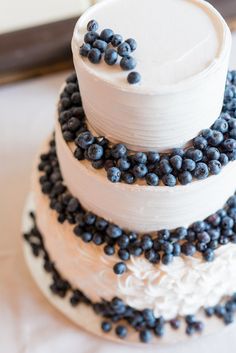 a three tiered cake with blueberries on top