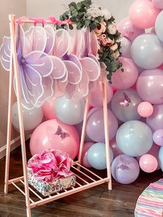 there is a pink and blue party with balloons on the wall, flowers and gifts