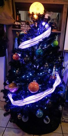 a blue christmas tree decorated with lights and ornaments