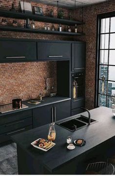 a modern kitchen with black cabinets and an island in front of a window overlooking the city