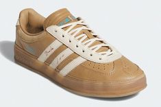 a tan and white adidas sneakers on a white background