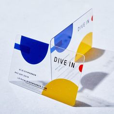 two business cards sitting on top of each other in front of a white background with blue, yellow and red circles