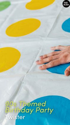 a person laying on top of a white and blue polka dot birthday party table cloth