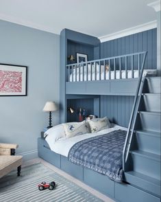 a bedroom with blue painted walls and stairs