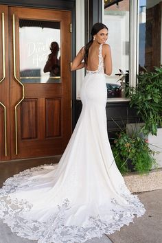 a woman in a wedding dress is standing outside