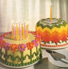 two cakes decorated with flowers and lit candles