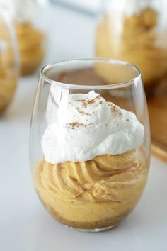 a dessert in a glass with whipped cream and cinnamon on the top is ready to be eaten