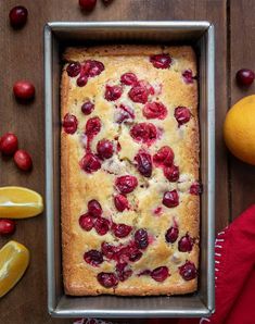 a cake in a pan with cherries and lemons around it