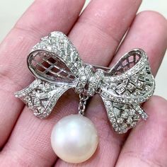 ART-DECO PEARL BROOCH! UNIQUE DESIGN! ONE OF A KIND THIS MASTERPIECE'S DESIGN WAS INSPIRED BY ART-DECO JEWELRY. A perfect size SOUTH SEA PEARL with excellent QUALITY AND PURE WHITE COLOR. The diamonds are extremely white and sparkling, giving this vintage-style brooch a perfect TOUCH OF SPARKLE. Set in handmade, one of a kind 18K Solid Gold brooch. The pearl is detachable as shown. Our jewelry are specially designed, and are delicately handcrafted by local Thai, professional goldsmiths, who have Elegant Brooches With Decorative Bow For Anniversary, Elegant Anniversary Brooches With Decorative Bow, Elegant Anniversary Brooch With Decorative Bow, Elegant Anniversary Brooch With Bow, Art Deco Platinum Brooches As Gift, Vintage Platinum Brooches With Diamond Accents, Luxury Vintage Diamond White Brooches, Vintage Gold Brooch With Pearl Pendant, Pearl Art