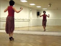 a woman in a red top is dancing on the dance floor with her reflection in a mirror