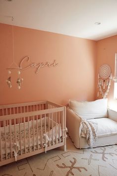 a baby's room with pink walls and white furniture