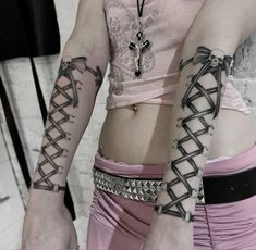 two women with tattoos on their arms and armbands are standing next to each other