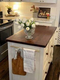 a kitchen island with flowers in a vase on it