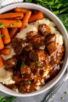 a bowl filled with mashed potatoes, carrots and meat