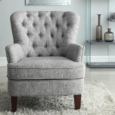 a gray chair sitting on top of a white rug