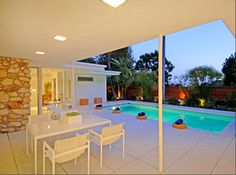 an outdoor dining area next to a swimming pool