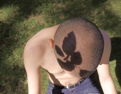 an overhead view of a man with his shadow on the back of his head, looking down