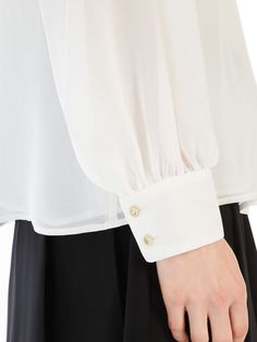 Find MAX MARA Pure Silk Georgette Blouse on Editorialist. Crew-neck blouse in lightweight pure silk georgette, featuring a flowing silhouette with long, wide raglan sleeves and wide cuffs with two jewelled buttons. Partially lined. Teardrop opening with a small button at the back. Elegant White Viscose Top, Luxury White Slub Silk Blouse Piece, Cutdana Embellished Long Sleeve Cotton Silk Top, Max Mara Shirt, White 3/4 Sleeve Top With Button Closure, Georgette Blouse, Wide Cuff, Max Mara, Raglan Sleeve