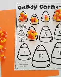 candy corn counting game for kids on an orange paper with candy corn in the middle