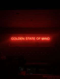 a red neon sign that says golden state of mind in the middle of a dark room