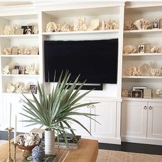 a living room filled with furniture and a flat screen tv mounted to the side of a wall