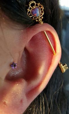 a close up of a person's ear with a key attached to the back of it