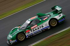 a green race car driving on a track