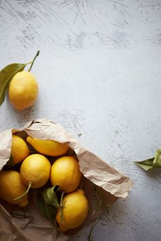 a paper bag filled with lemons on top of a table