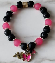 made with durable stretch cord pink glass black onyx is a valuable stone that provides strength Pink Jewelry With Adjustable Black Beads, Black Charm Bracelet With Round Beads, Adjustable Black Charm Bracelet With 8mm Beads, Adjustable Pink Stretch Bracelet With Gemstone Beads, Adjustable Pink Gemstone Bead Stretch Bracelet, Black Beaded Charm Bracelet, Black Adjustable Stretch Bracelet With Gemstone Beads, Black Stretch Bracelet With Black Beads, Adjustable Black Onyx Bead Stretch Bracelet