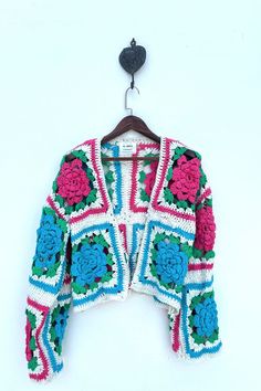 Vintage  Boho Chic Wool Cardigan Coat This unique seasonal cardigan coat is crafted from vintage hand-knitted wool crochet with intricate granny square pattern in vibrant colours Key Features: Material: Vintage hand-knitted wool crochet Design:Granny square patterns  Fit- Effortlessly easy fit, one size fits all Ideal for - Layering piece for slightly chilly days Garment Measurements Flat lay: - Chest( pit to pit) : 20 inches/ 66 cm - Shoulder: 23 inches / 59 cm  - Length: 21 inches / 137 cm - Sleeve: 21 inches / 51 cm Size: S/M  This vintage piece is perfect for those who appreciate unique, handcrafted fashion. Please Note: Due to use of Vintage fabric almost 20-50 years old that has been up cycled, there might be some imperfections on the fabric. These irregularities add to the charm of Upcycle Vintage, Wool Crochet, Boho Layering, Crochet Short, Sleeve Crochet, Crochet Vintage, Crochet Coat, Granny Squares Pattern, Floral Crochet