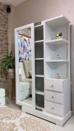 a large white cabinet with drawers and mirror on the wall next to a bed in a room