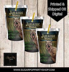 three party cups with yellow straws in front of wooden planks and the words jubasic world printed on them